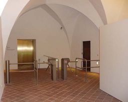 Zugangskontrollen am Besucheraufzug in der Albrechtsburg zu Meißen, Zugang im Erdgeschoss. Neben den Drehkreuzen sind Klappbügel als barrierefreie Durchlässe platziert. 