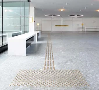 Gestaltung des Blindenleitsystems des Staatstheater Darmstadt. Leitstreifen und Aufmerksamkeitsfelder bestehen aus Rippen und Noppen aus Messing.