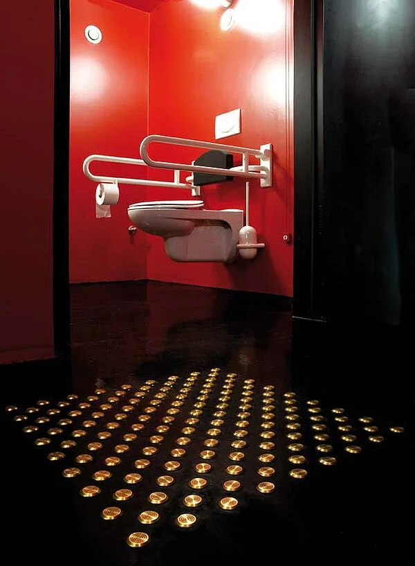 Kontrastierend gestaltete barrierefreie Toilette (rote Wände, weiße Sanitärgegenstände, schwarzer Fußboden und schwarze Rückenlehne) mit Anbindung an das Bodenleitsystem, Staatstheater Darmstadt